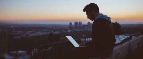 Guy with Laptop sitting on a Roof
