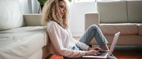 Frau arbeitet zuhause am Laptop