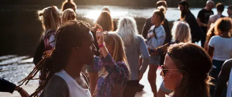 Crowd of people standing by a lake