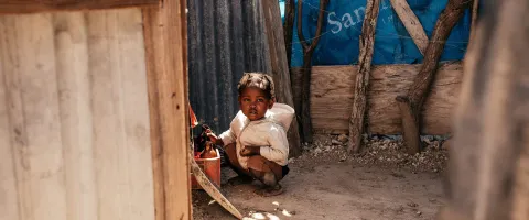 Small child inside of a home in a poor area