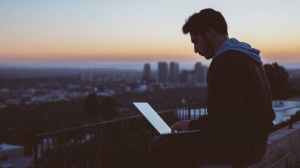 Guy with Laptop sitting on a Roof