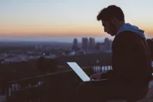 Guy with Laptop sitting on a Roof