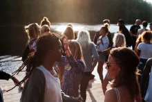 Crowd of people standing by a lake