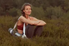 Frau nachdenklich mit Yogamatte